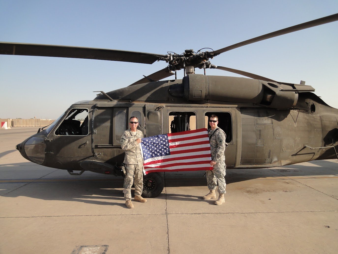 Anthony Gadd, in a military uniform holding an American flag