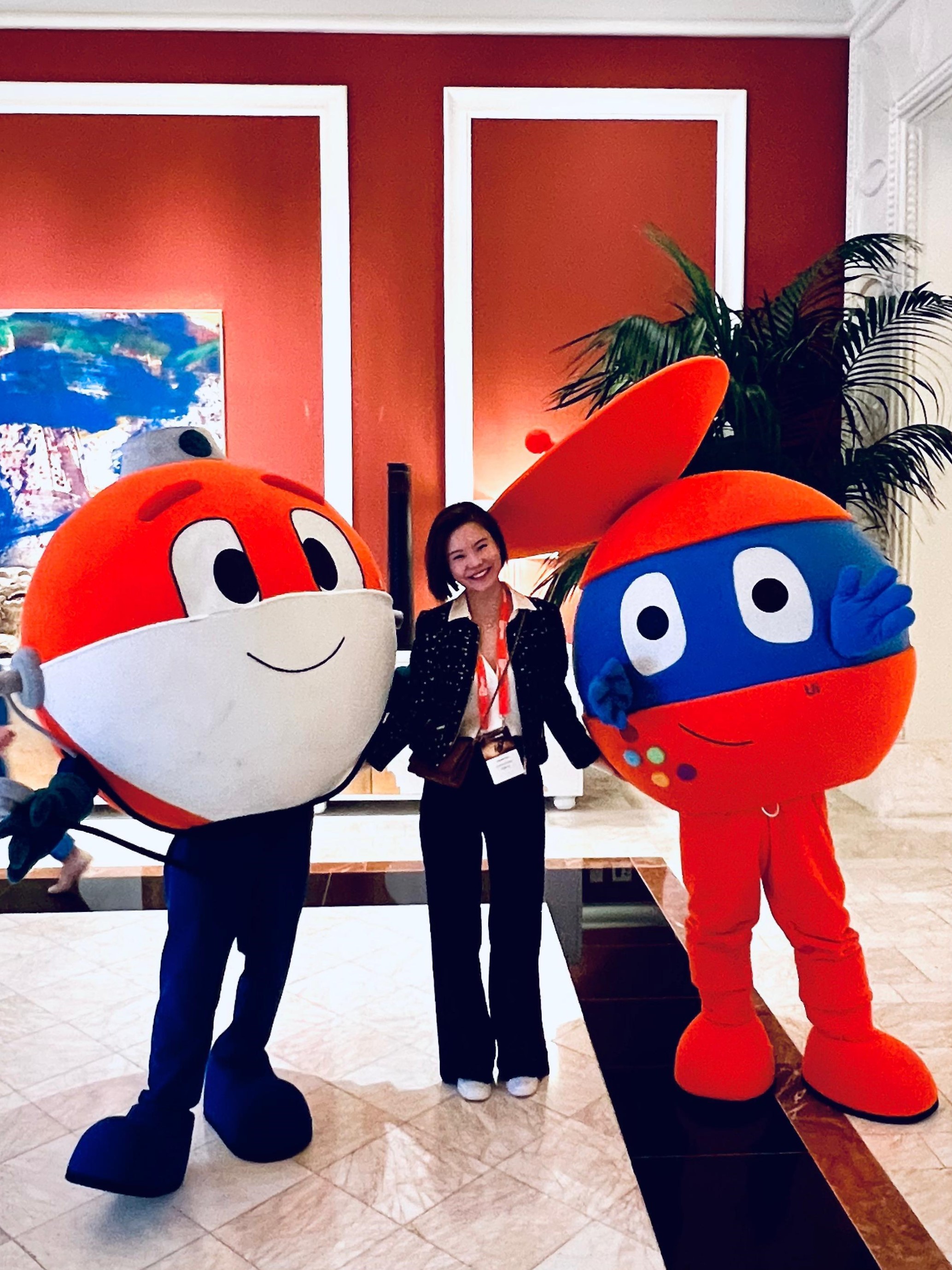 a photo of Chantel posing with two UiPath mascots