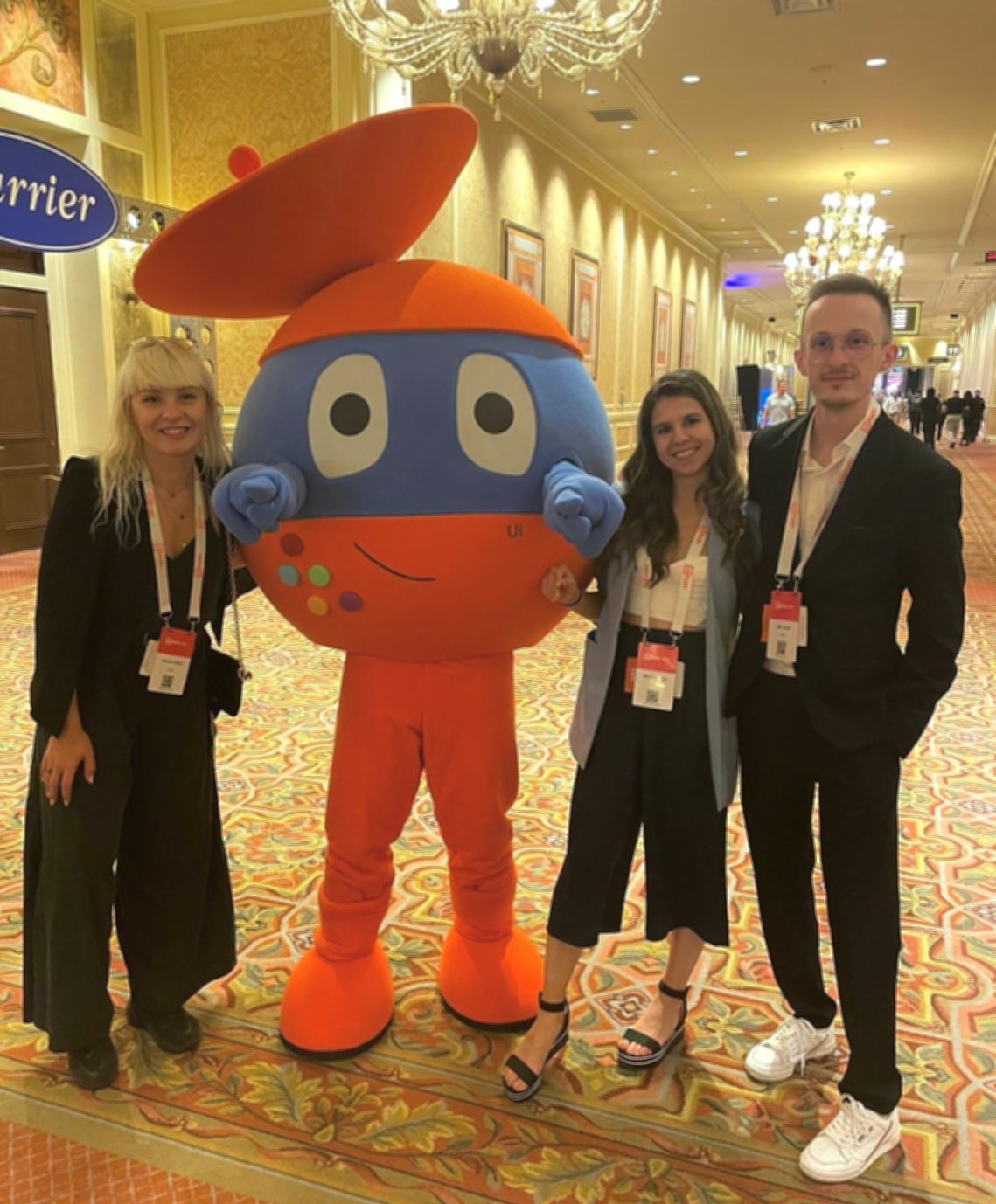 a group photo with Alexandra, one of the UiPath robot mascots, and other colleagues