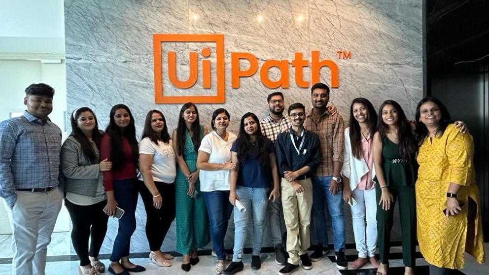 a photo of UiPathers posing in front of the UiPath logo