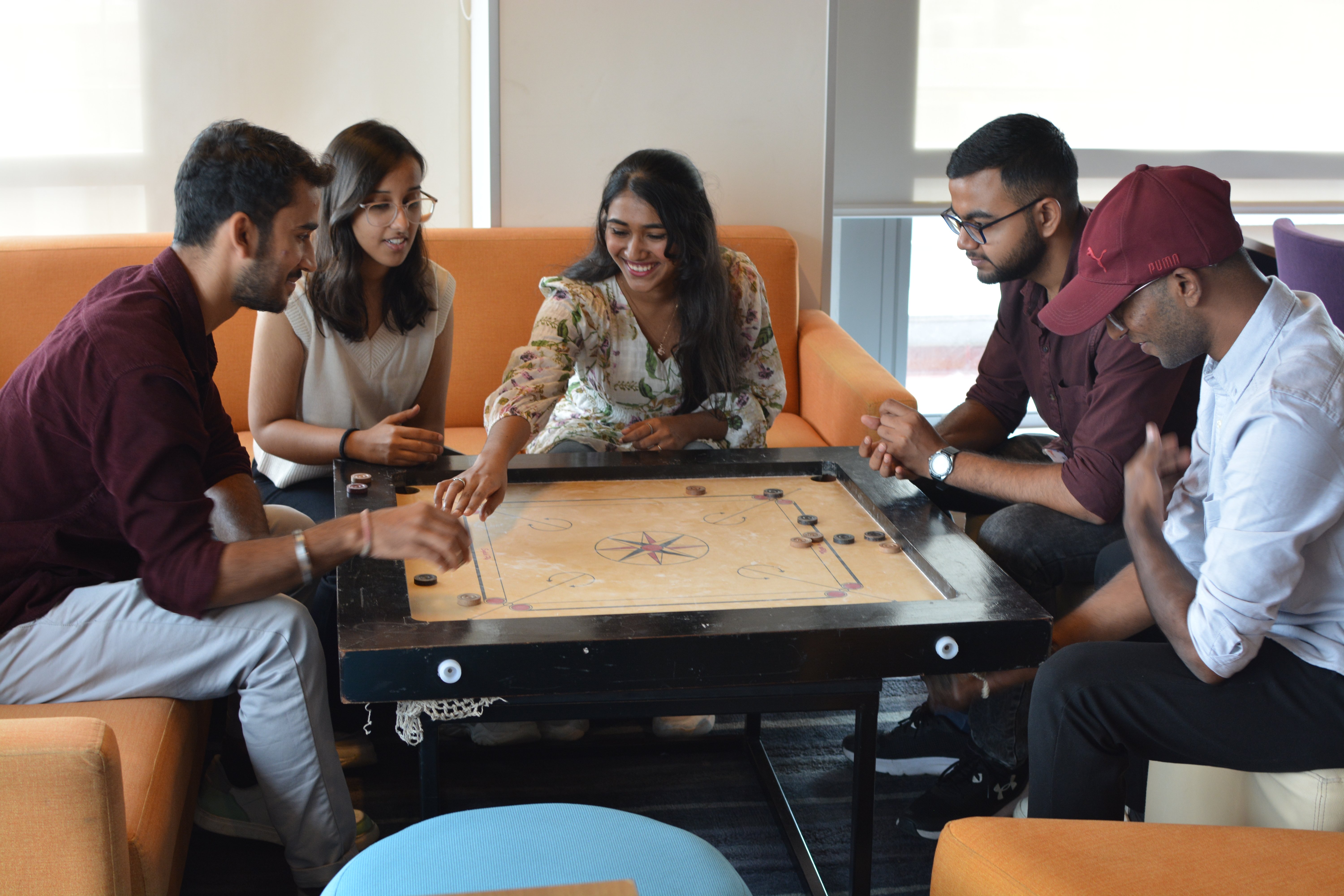 a group of Product Support interns playing a board game together