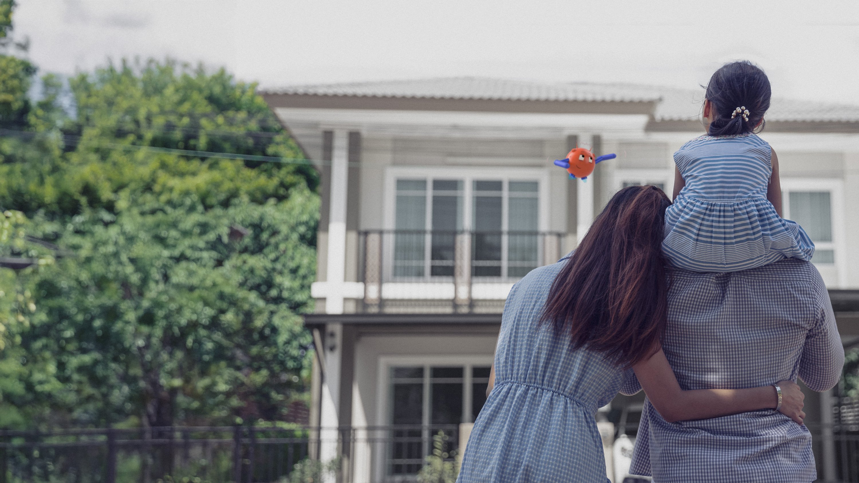 a photo of a family hugging and looking at their house