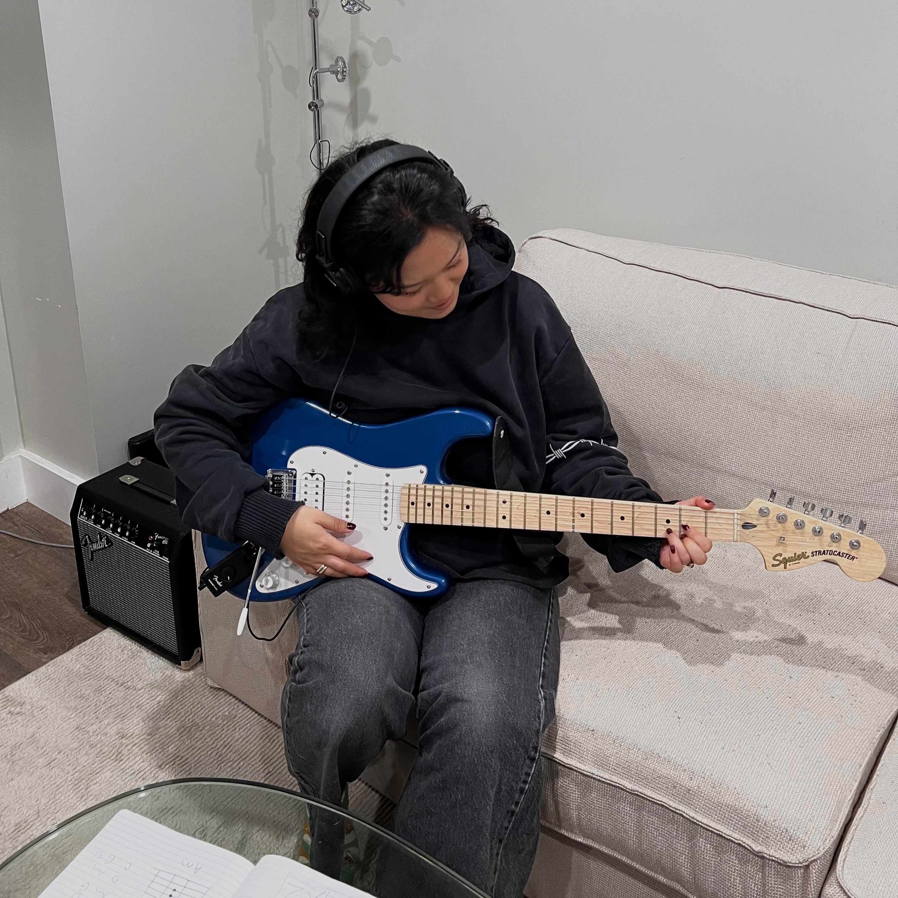 A photo of Yuri Yim practicing her electric guitar skills