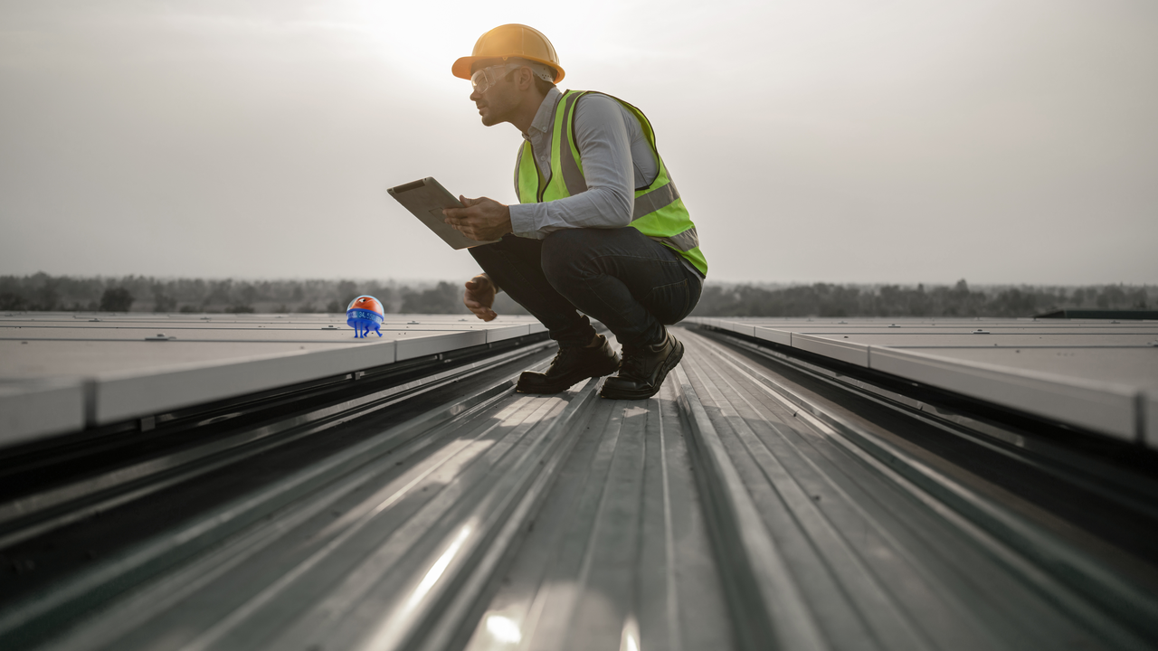 man on a roof wearing a hardhat