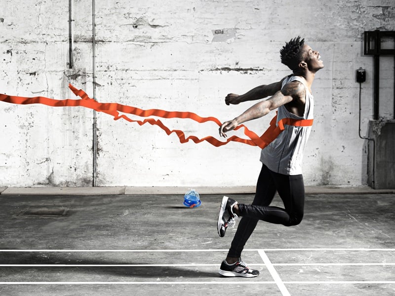 Runner at a finish line breaking tape