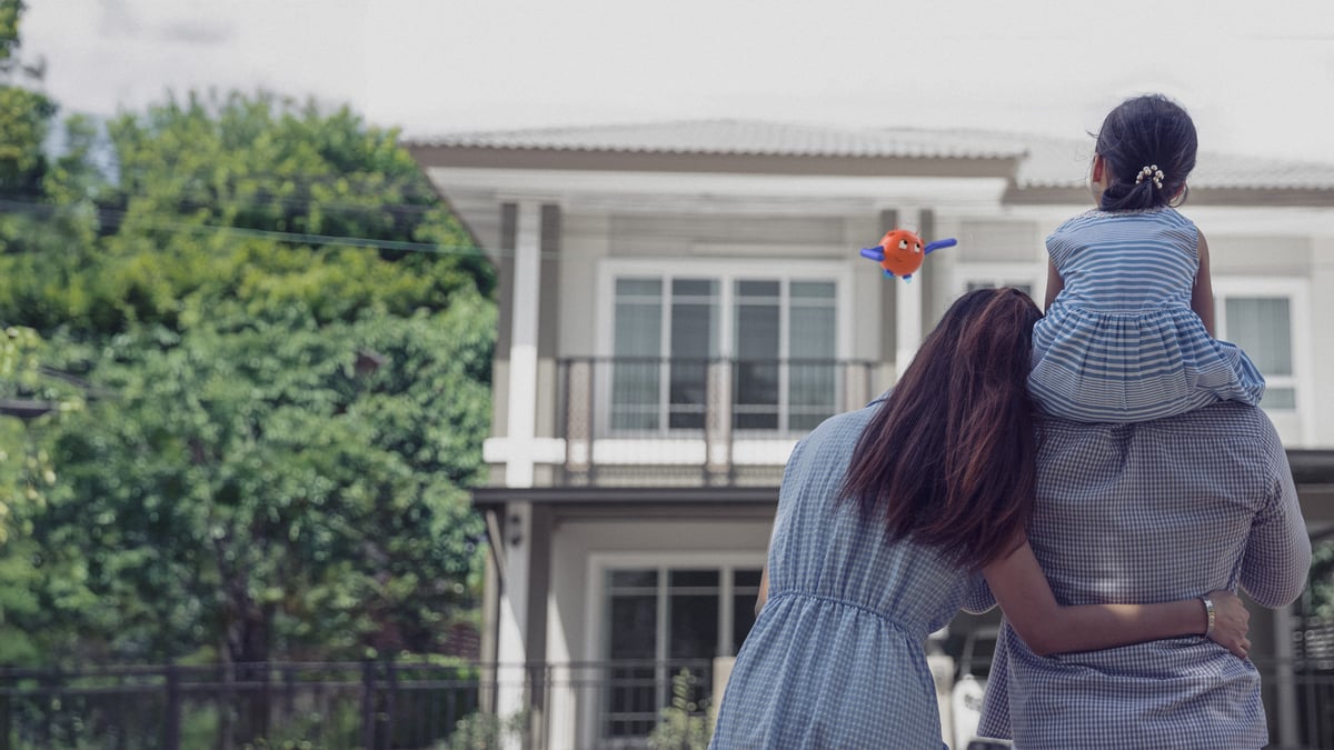 a photo of a family hugging and looking at their house