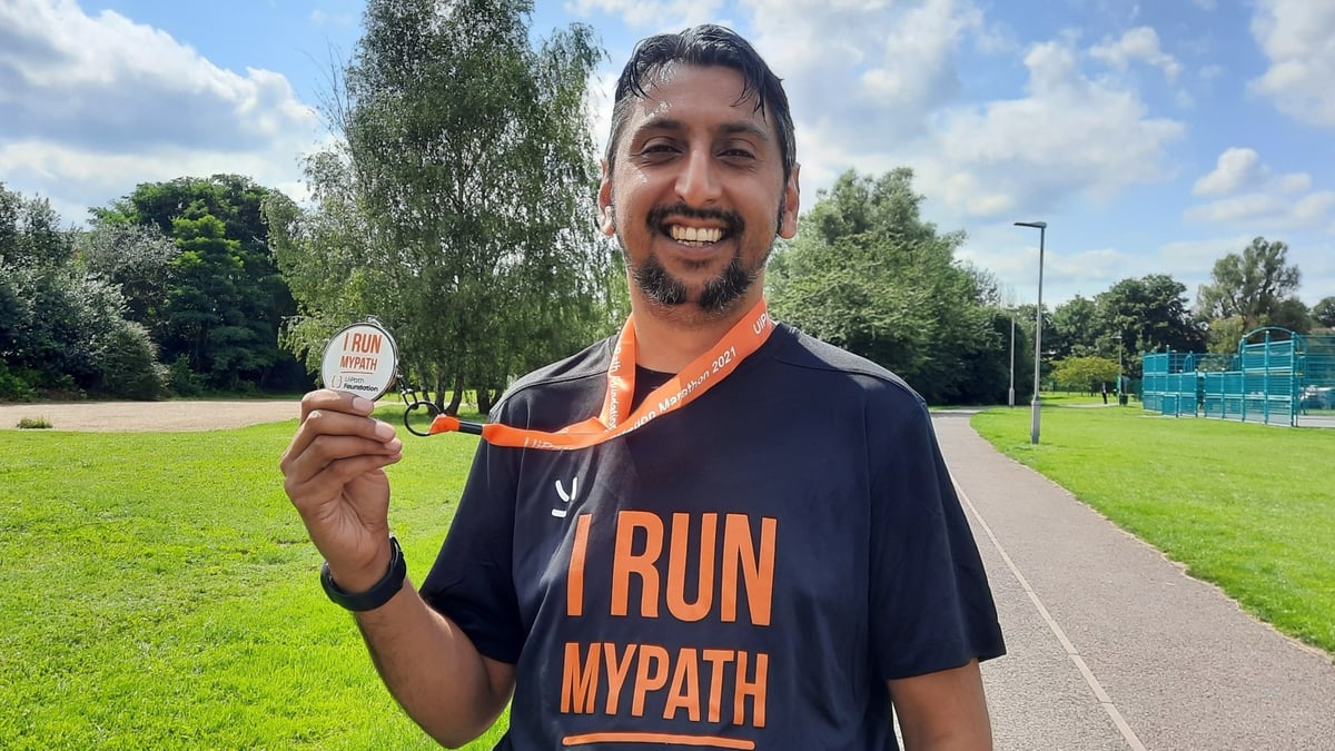 a photo of Arif Khan holding a marathon badge