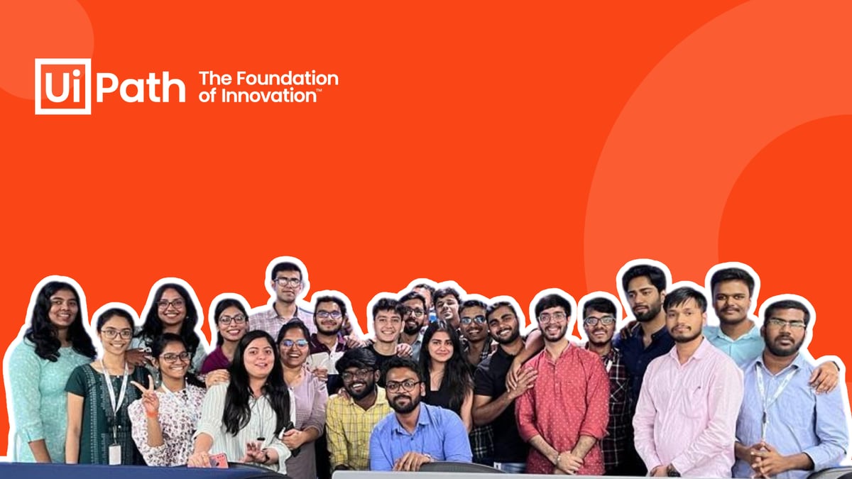 A group photo of the 2023 UiPath interns in India, on an orange background, with a white UiPath logo on the top-left
