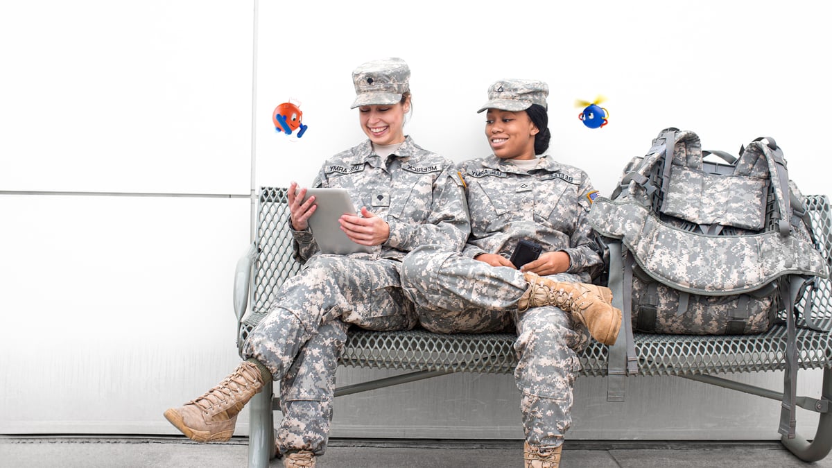 Two female soldiers sitting on the bench looking at files