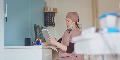 Healthcare worker studying EMR UiPath Robot Assistant on desk