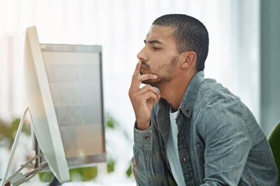 thinking man siting in front of a laptop