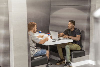 two people sitting in a booth