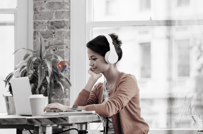 woman with headphones sitting in front of laptop