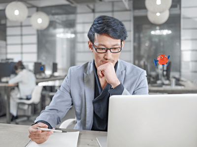 man sitting at table watching laptop