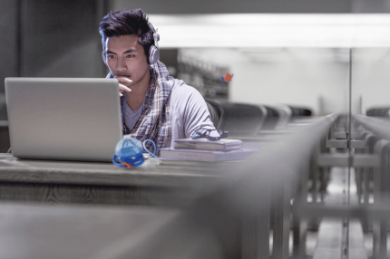 man sitting looking at a laptop