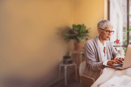 Woman sitting at a table using a laptop