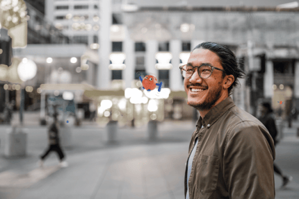 Person smiling outside next to flying robot