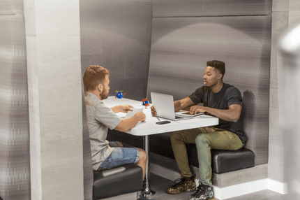 two people sitting in a booth