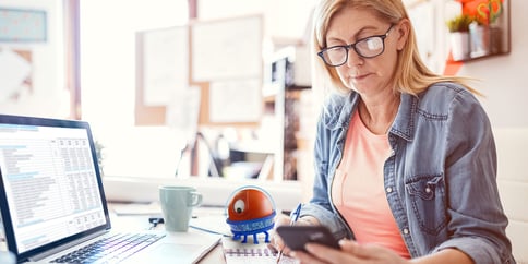 woman working from home uipath robot assistant reviewing work on desk