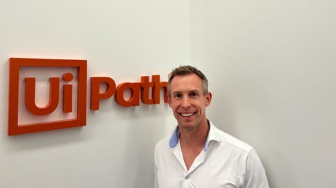 A picture of John Smith standing next to the Uipath logo