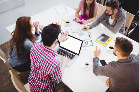 High-angle-view-of-young-partners-discussing-in-meeting-room-at-creative-office