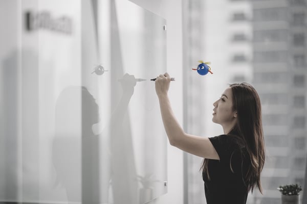 woman writing on whiteboatd UiPath robot