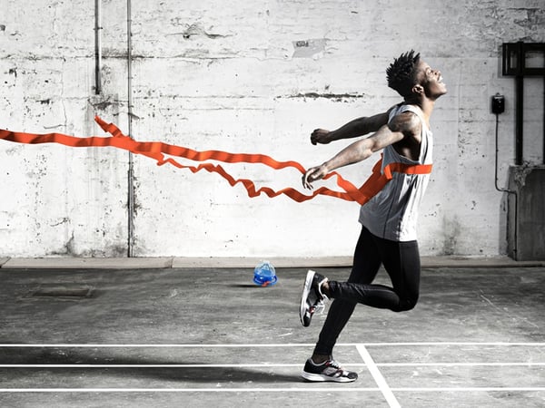 Runner at a finish line breaking tape