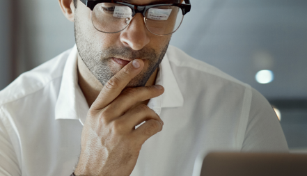 thinking man looking at laptop